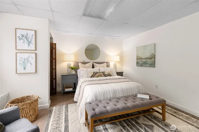 a bedroom with a bed and painting on the wall