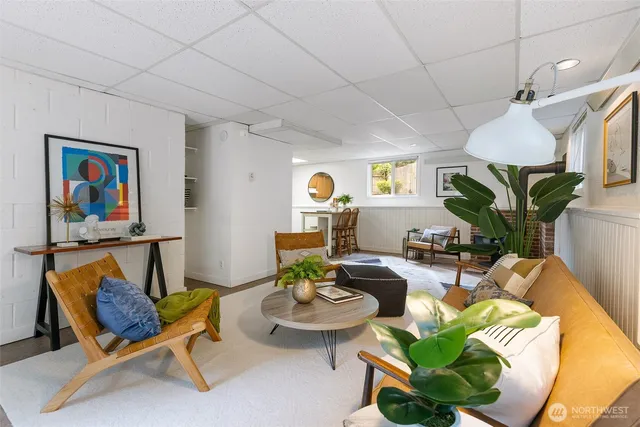a living room with furniture a rug and wall paintings