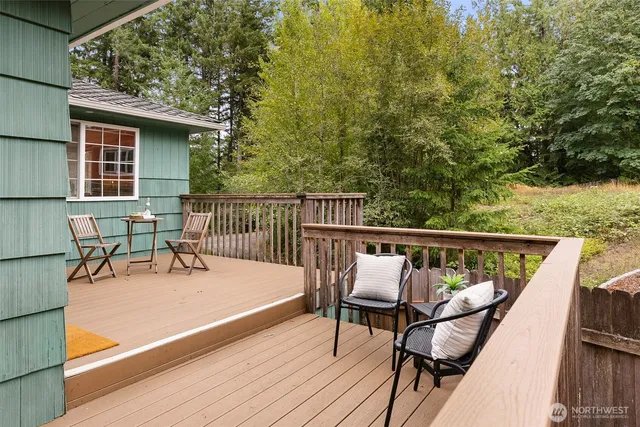 a balcony with wooden floor table and chairs
