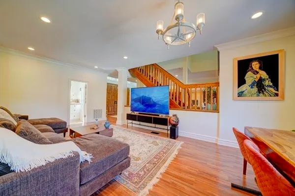 a bedroom with a bed dresser and wooden floor
