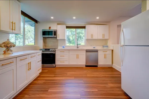 a kitchen with a sink window and cabinets