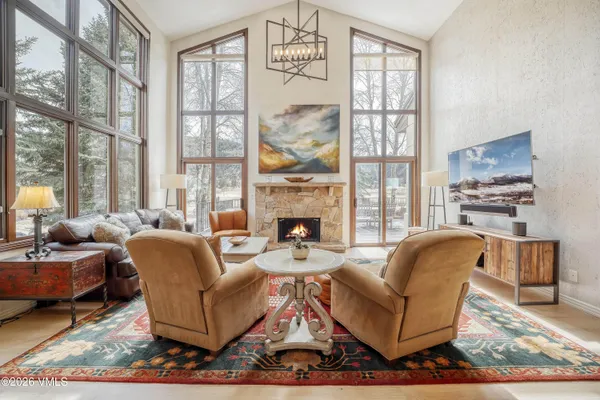 a living room with fireplace furniture and a large window