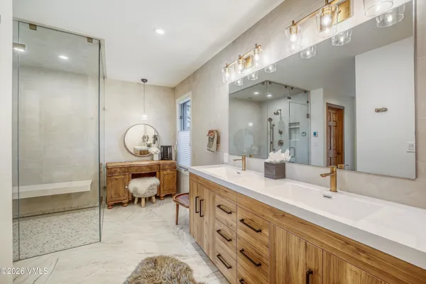 a spacious bathroom with a double vanity sink a mirror and a