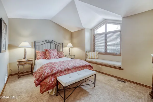 a bedroom with a bed lamp and a window