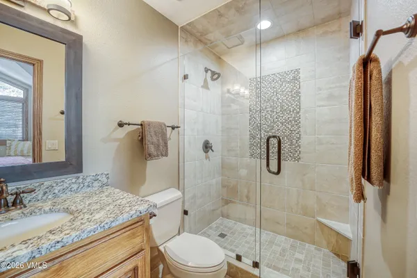 a bathroom with a granite countertop sink toilet and shower