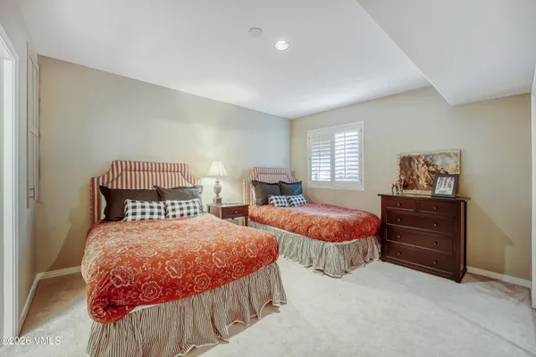 a bedroom with two beds and painting on the wall