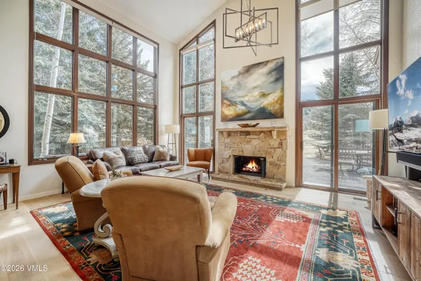a living room with furniture a fireplace and a floor to ceiling window