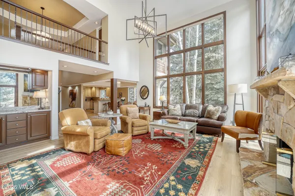 a living room with furniture a rug and a floor to ceiling window