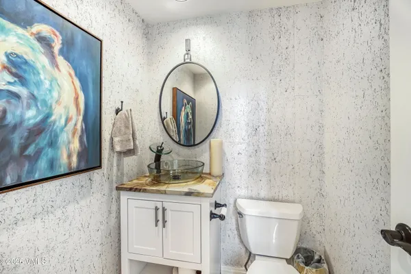 a bathroom with a toilet sink vanity and mirror