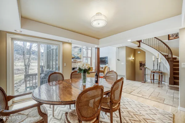 a dining room with furniture a chandelier and wooden floor