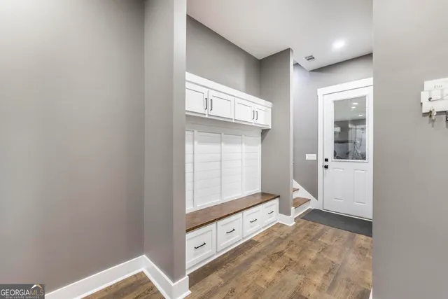 a kitchen with stainless steel appliances granite countertop a lot of cabinets and wooden floor