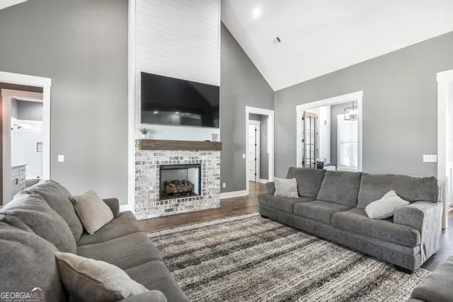 a living room with furniture a flat screen tv and a fireplace