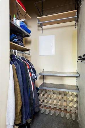 a view of walk in closet with clothes and shoes