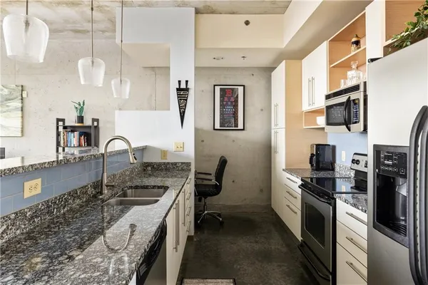 a kitchen with stainless steel appliances granite countertop a sink stove and refrigerator