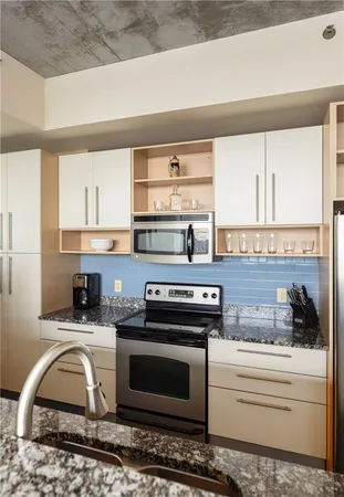 a kitchen with stainless steel appliances kitchen island granite countertop a stove a sink and a microwave