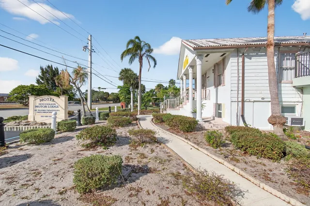 a front view of a house with parking space and palm trees
