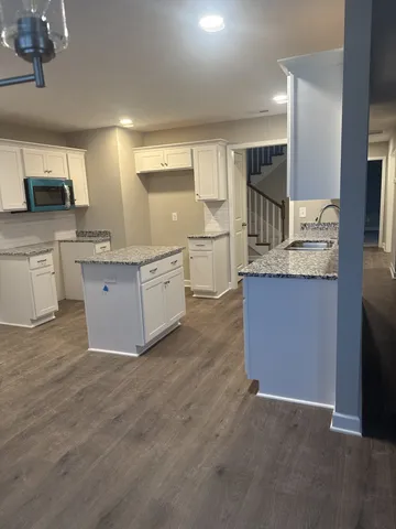 a large kitchen with stainless steel appliances granite countertop a stove and a sink