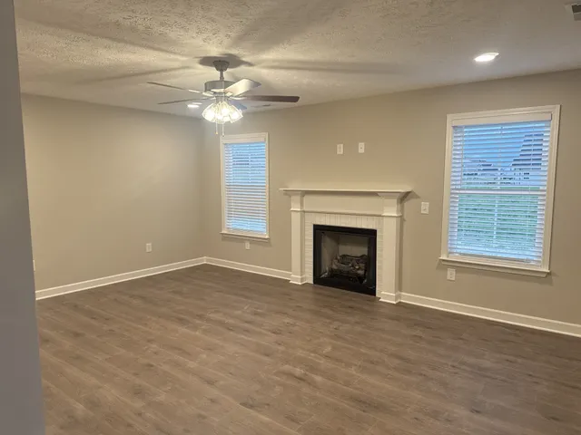 an empty room with windows and a fireplace
