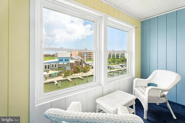 a view of a dining room with furniture a rug and a window
