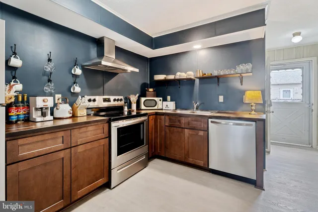 a kitchen with stainless steel appliances granite countertop a sink and a stove