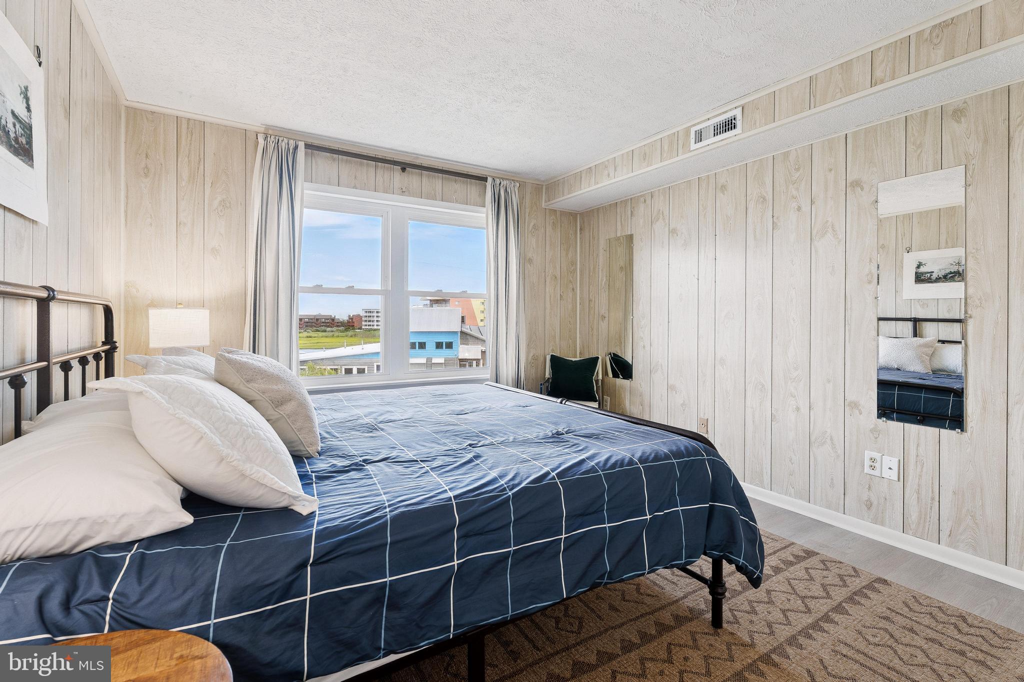 120 53rd Street, Unit H30102 Ocean City, MD 21842 - Photo 23 of 53 a bedroom with a bed a mirror and a window