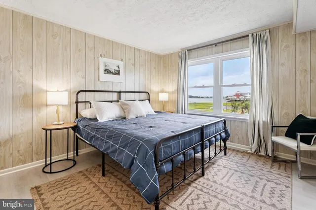 a bedroom with a bed and painting on the wall