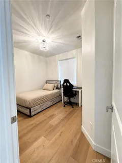 a spacious bedroom with a bed and a chandelier