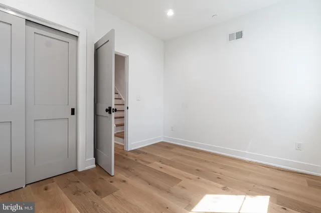 an empty room with wooden floor and closet