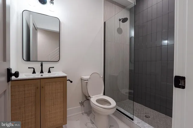 a bathroom with a toilet sink vanity and mirror