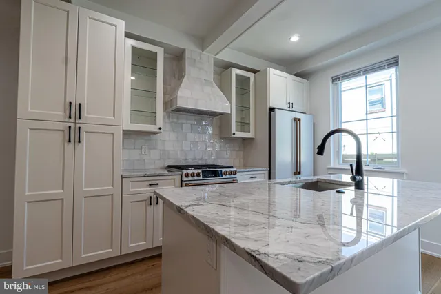 a kitchen with stainless steel appliances granite countertop a sink a stove and a refrigerator