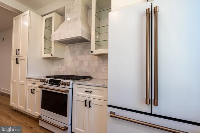 a kitchen with granite countertop white cabinets and white appliances