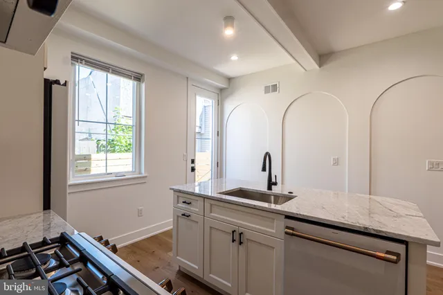 a bathroom with a granite countertop sink a large mirror and a window
