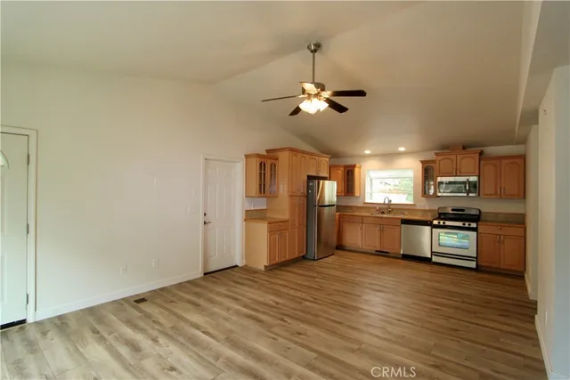 a large kitchen with cabinets wooden floor and stainless steel appliances