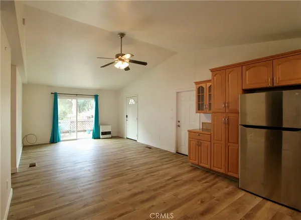 a view of a kitchen with a refrigerator a ceiling fan and wooden floor