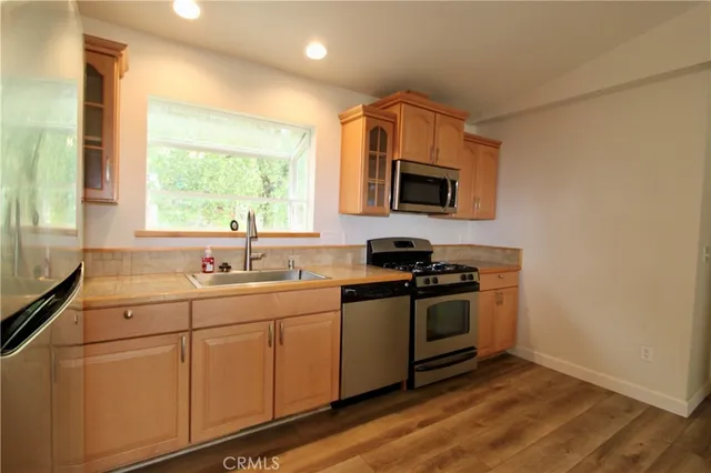 a kitchen with stainless steel appliances white cabinets a sink and a stove