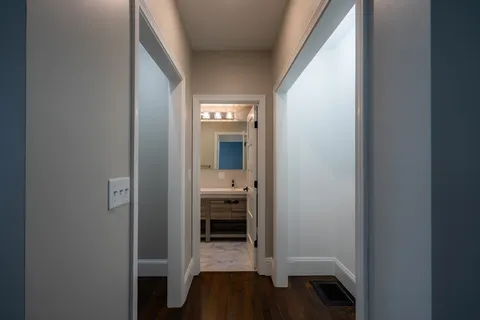 a view of a hallway with a livingroom and a bathroom with sink