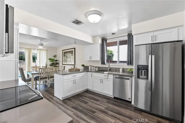 a kitchen with white cabinets and stainless steel appliances