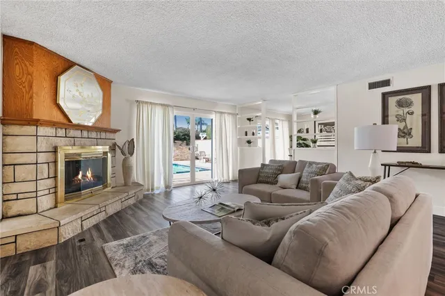 a living room with furniture a window and wooden floor