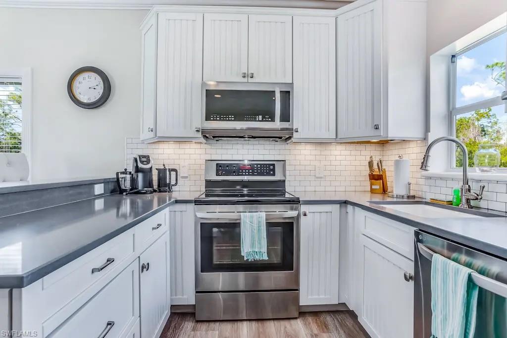 6941 Hunters Road Naples, FL 34109 - Photo 13 of 48 a kitchen with a stove and a sink