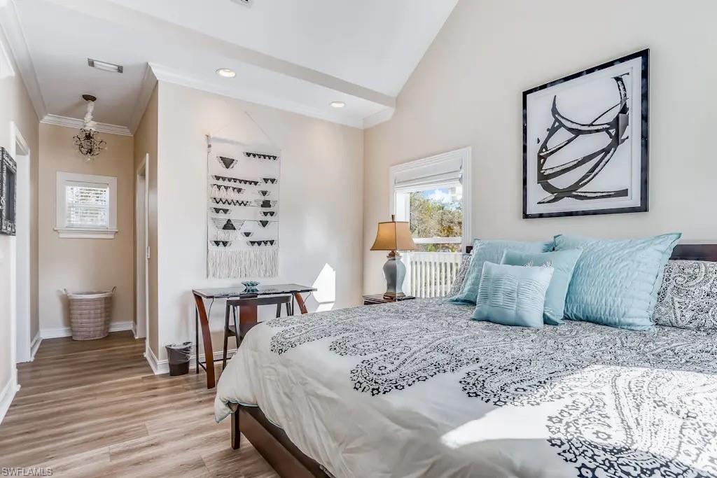 6941 Hunters Road Naples, FL 34109 - Photo 15 of 48 a bedroom with a large bed and a chandelier