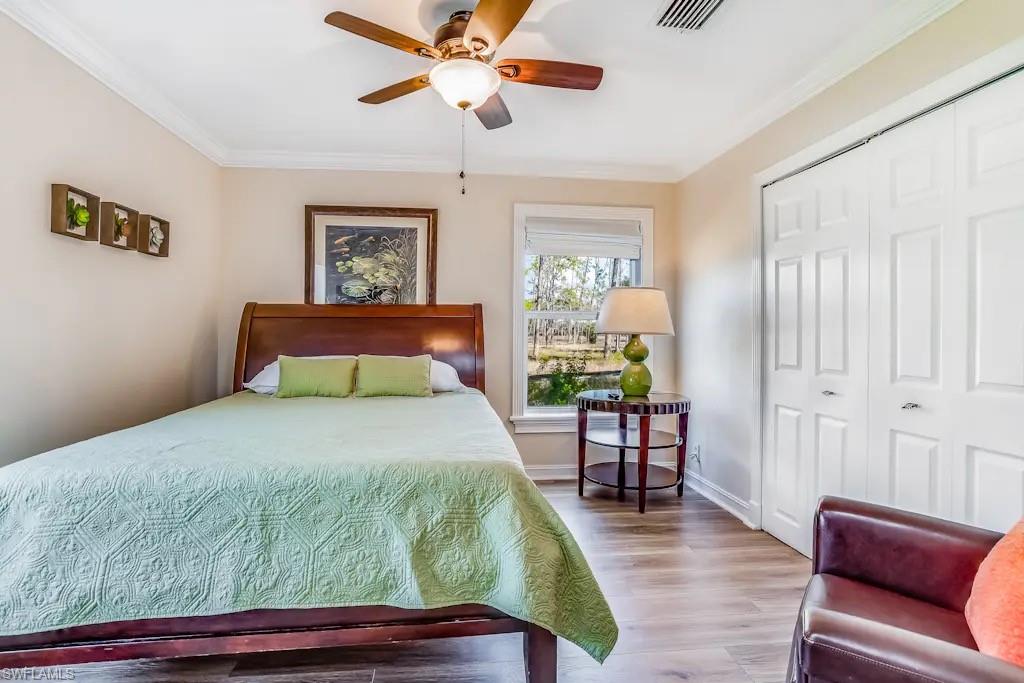 6941 Hunters Road Naples, FL 34109 - Photo 18 of 48 a bedroom with a bed and wooden floor