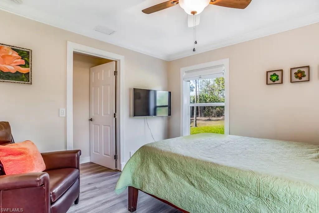 6941 Hunters Road Naples, FL 34109 - Photo 19 of 48 a bedroom with a bed and wooden floor