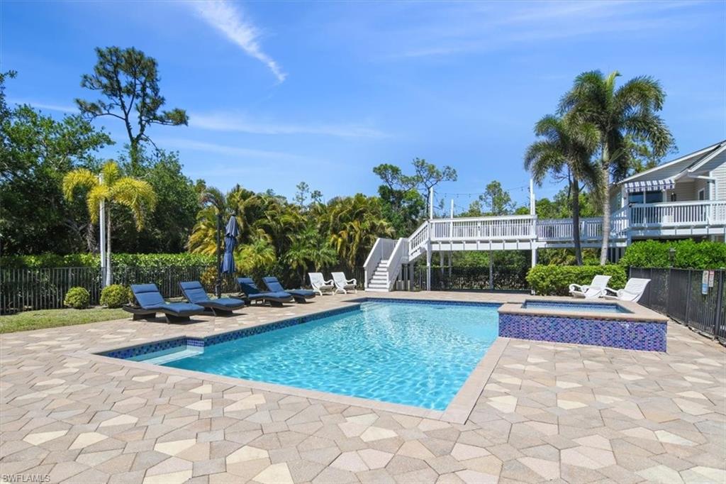 6941 Hunters Road Naples, FL 34109 - Photo 2 of 48 a view of a swimming pool and lounge chairs