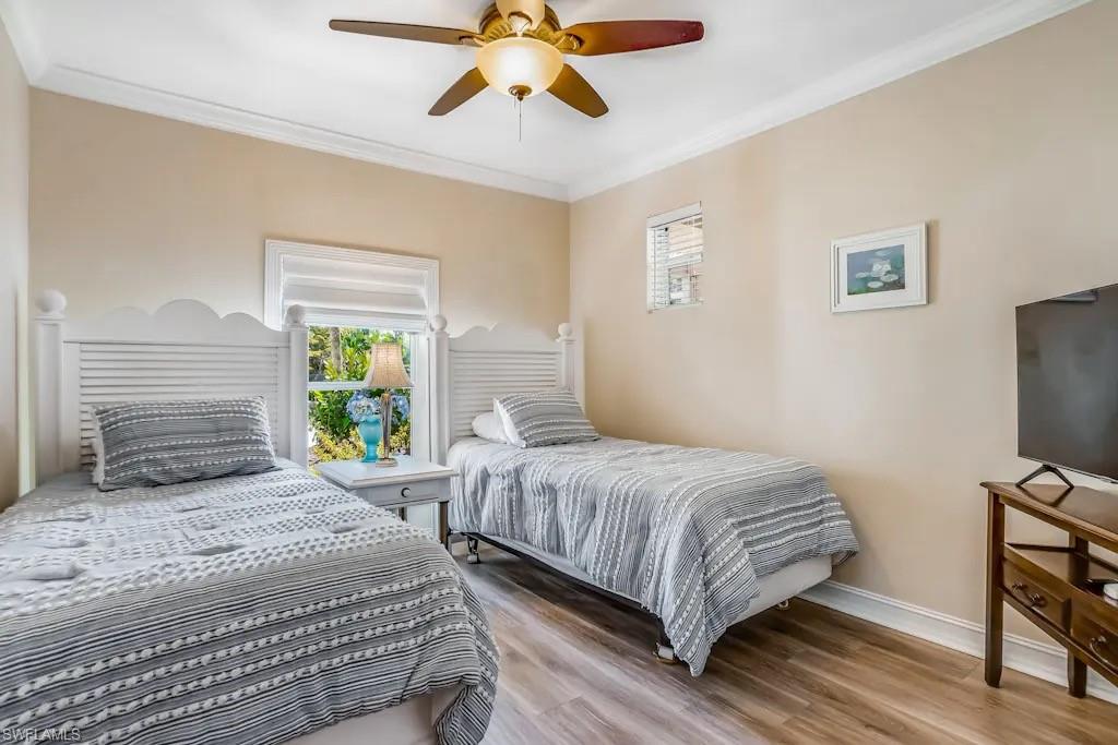 6941 Hunters Road Naples, FL 34109 - Photo 21 of 48 a bedroom with a bed a window and a flat screen tv