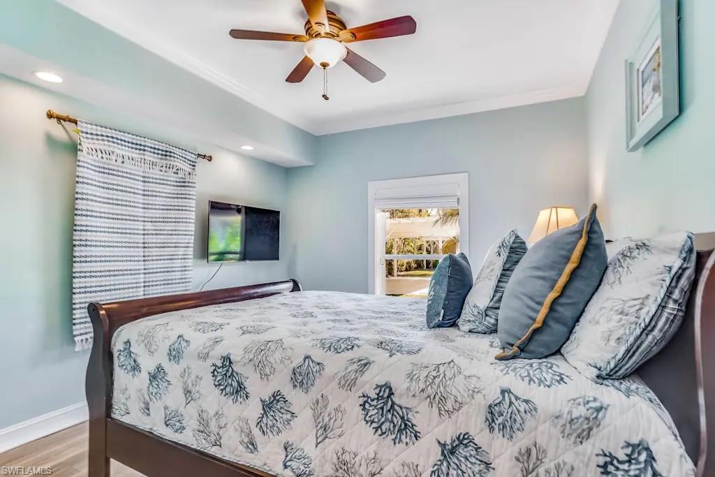 6941 Hunters Road Naples, FL 34109 - Photo 23 of 48 a bedroom with a bed and a chandelier