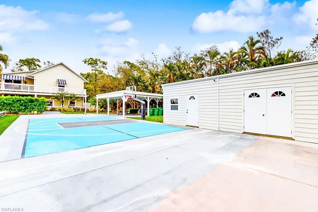 6941 Hunters Road Naples, FL 34109 - Photo 30 of 48 a view of a white house with a yard and potted plants