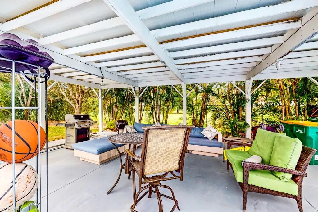 6941 Hunters Road Naples, FL 34109 - Photo 48 of 48 a dining room with furniture and a garden