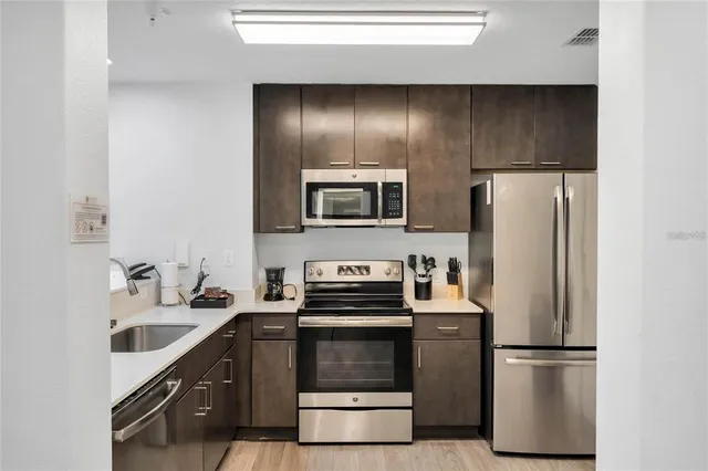 a kitchen with granite countertop a refrigerator and a stove top oven
