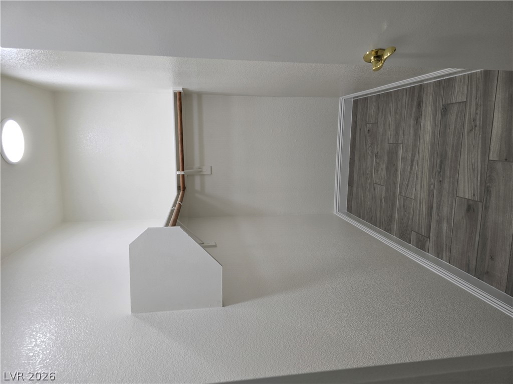 1881 West Alexander Road, Unit 1127 North Las Vegas, NV 89032 - Photo 18 of 20 Minimalist interior with a distinctive round window, offering a clean, adaptable space.