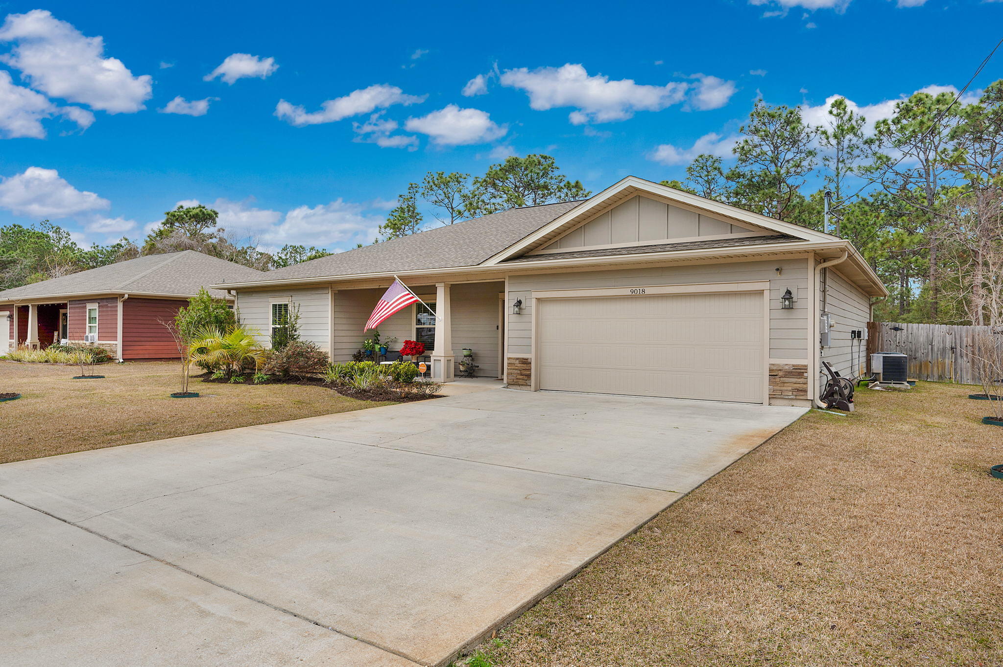 9018 Timber Lane Navarre, FL 32566 - Photo 2 of 39 a front view of a house with a yard and garage